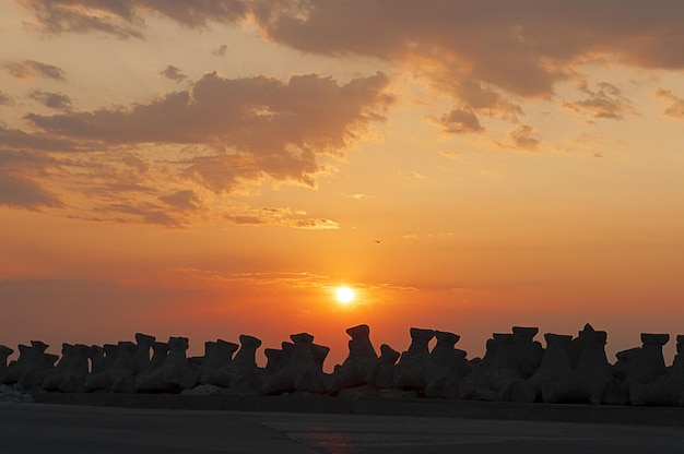 Sunrise above a wall of protective stone tetrapods