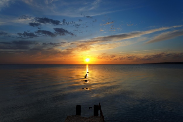 Sunrise over water with destroyed bridge soft focus