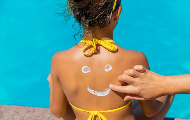 Sunscreen on the back of the child. Selective focus. Kid.