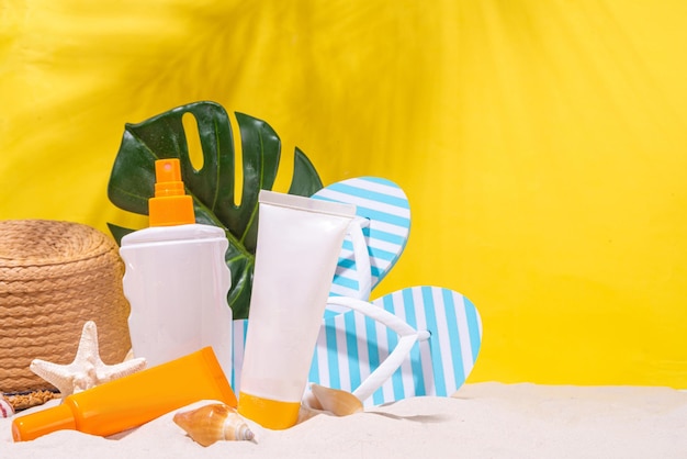 Sunscreen bottles on sand background