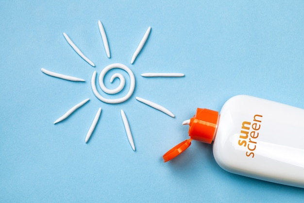 Sunscreen. Cream in the form of sun on blue background with white tube.