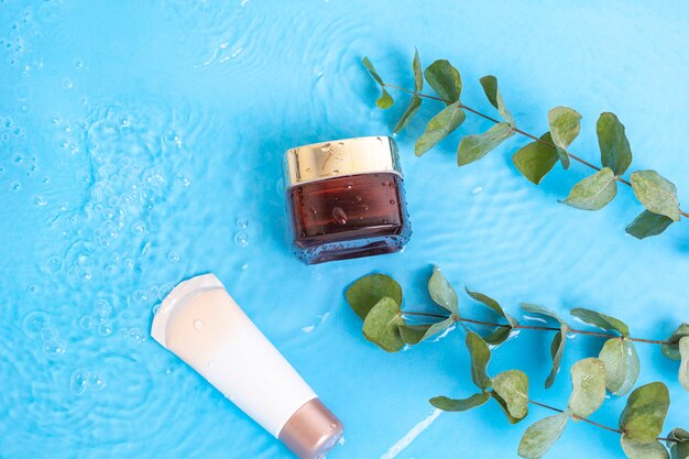 sunscreen cream spf lotion to skin with eucalyptus leaves on blue water pool