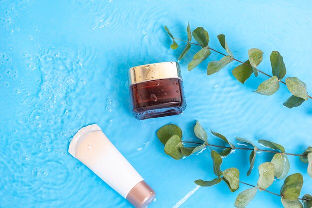 Sunscreen cream spf lotion to skin with eucalyptus leaves on blue water pool