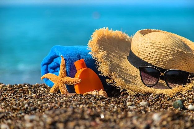 Foto crema solare e occhiali in spiaggia. messa a fuoco selettiva. viaggio.