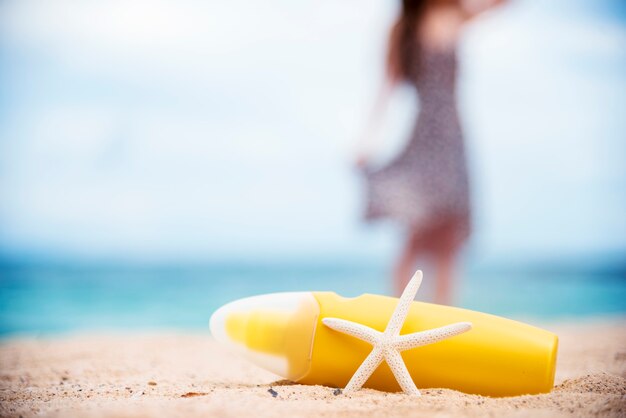 Солнцезащитный лосьон защищает женскую кожу на тропическом летнем открытом пляже.