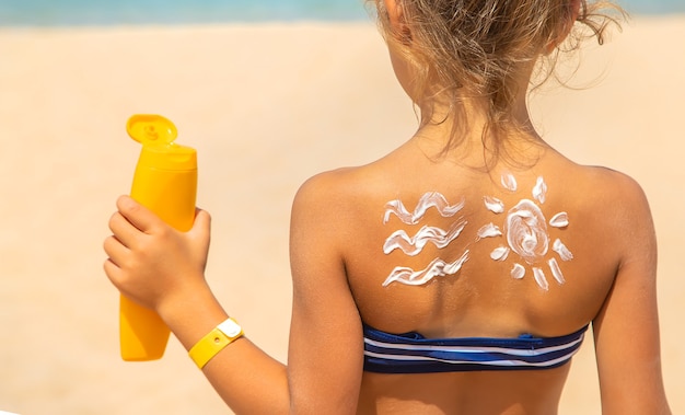 Солнцезащитный крем на коже ребенка. Выборочный фокус. природа.