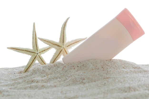 Sunscreen and starfish on sand