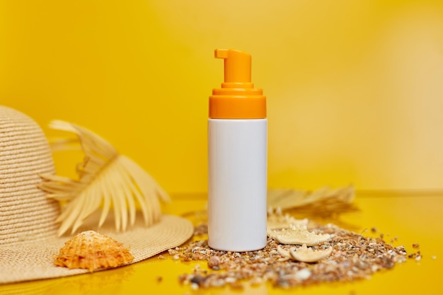 Sunscreen tube mockup with shells sand yellow background