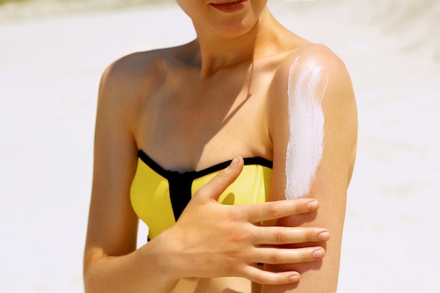 Sunscreen woman Woman applying sunscreen on tanned skin