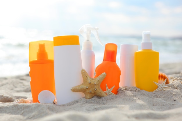 Foto creme solari sulla spiaggia vicino al mare da vicino