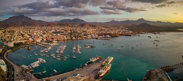 Sunset aerial view of Mindelo with marina boats cityscape mountains and a glowing sky