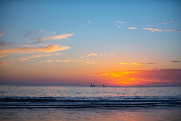 ビーチでの海の日の出の夕日カラフルな海のビーチの日の出