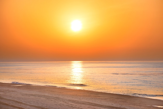長い海岸線、太陽と劇的な空とビーチに沈む夕日