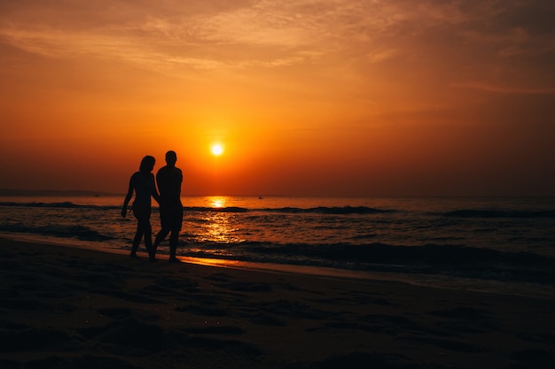 sunset at the beach with silhouette of couple