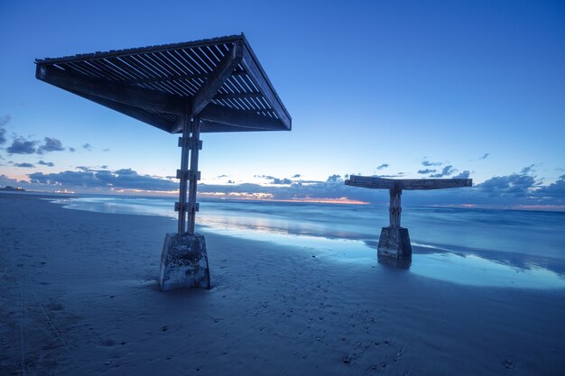 Foto tramonto sulla spiaggia con ombrelloni. serata sulla spiaggia deserta. cesarea, israele