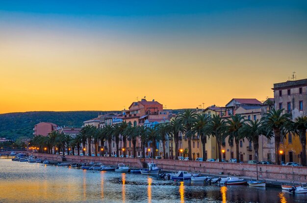 Foto il tramonto su bosa con il fiume temo e le palme in sardegna, in italia