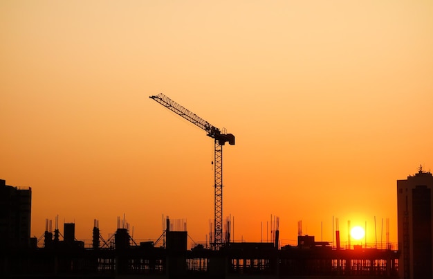 Sunset over Building construction in the city Crane and structure silhouettes