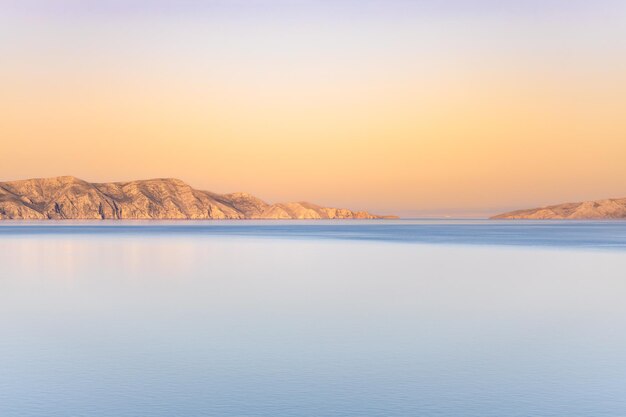 Sunset in a calm sea in the evening in good weather sandy islands in the distance rest on the sea