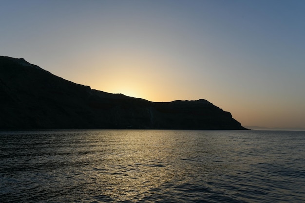 산토리니 키클라데스 섬의 칼데라에 있는 티라시아의 절벽 위에서 해가 지는 모습 그리스 유럽