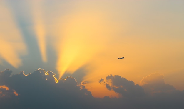 雲に沈む夕日と空の飛行機に飛ぶ