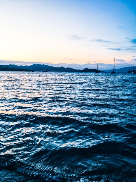 海岸の美しい海の景色の背景に沈む夕日