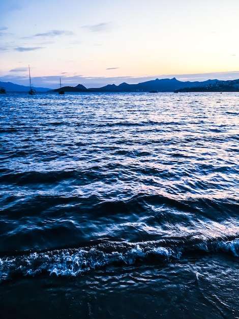 海岸の美しい海の景色の背景に沈む夕日