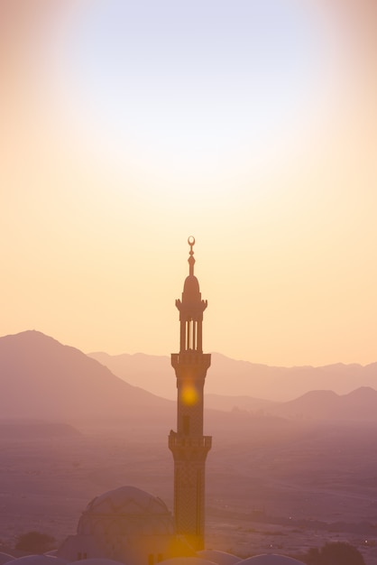 Sunset over desert with muslim mosque