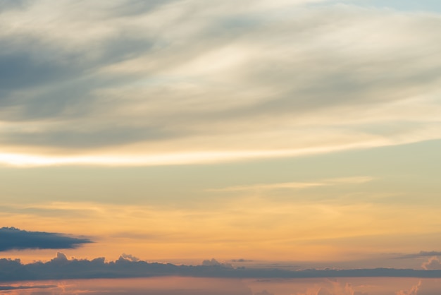 Nuvole arancioni drammatiche del cielo blu di tramonto