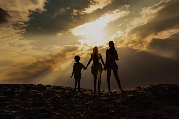 Sunset and family on the sand silhouettes of people on the beach success and family unity