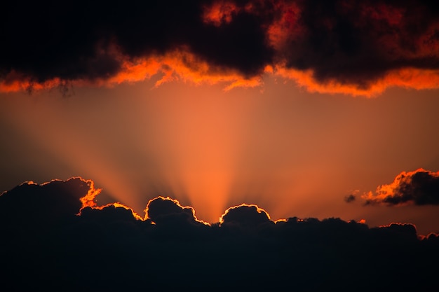 写真 夕焼け下から雲から光線が出て雲が上からぶら下がっているコピースペース