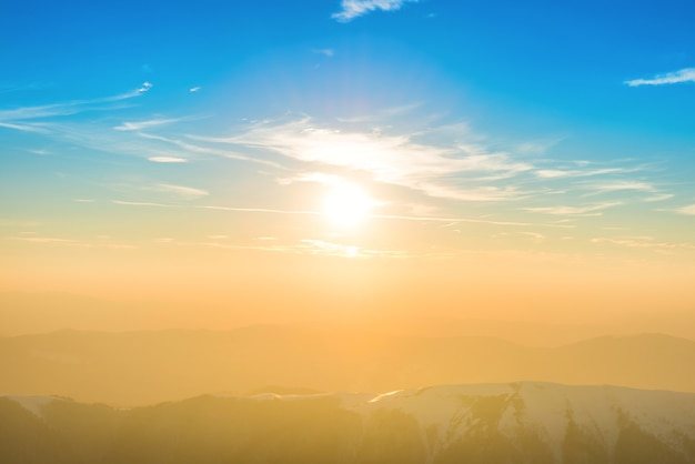 Sunset over hills and mountains with snow