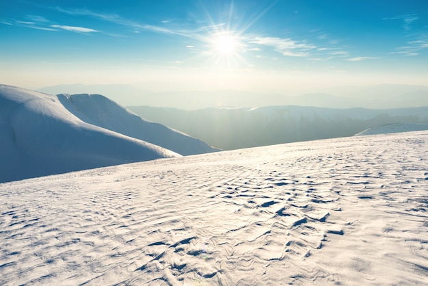 Tramonto su colline e montagne con la neve