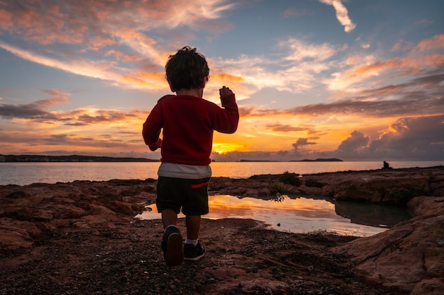 Sunset in Ibiza on vacation a child running and laughing by the sea in San Antonio Abad