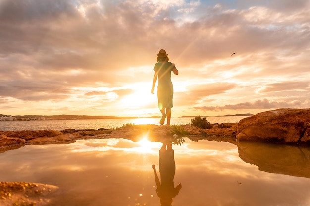 Sunset in Ibiza a young tourist enjoying in San Antonio Abad Balearic