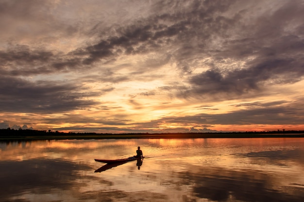 Sunset in the lake. beautiful sunset behind the clouds above the over lake landscape backg