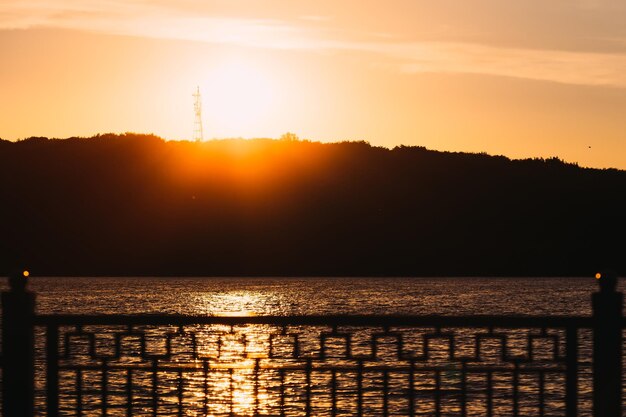 sunset and lake shore of the lake and the fence