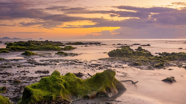 Sunset landscape on the beach rocks in foreground