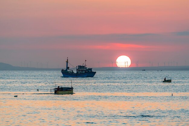 Sunset landscape when fishing boats out to sea to harvest fish\
end the day.