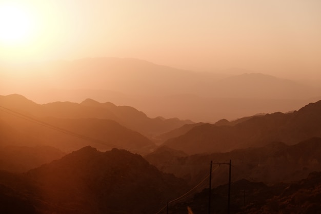 Sunset over layer of mountain ranges.