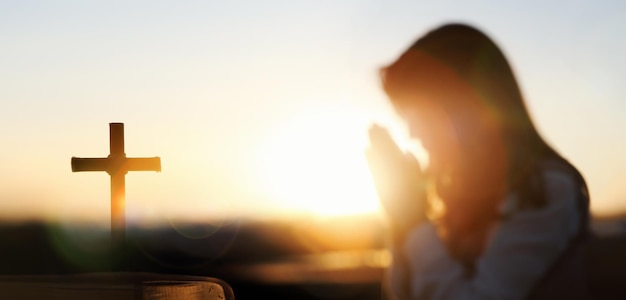 Foto sfondo chiaro tramonto, sacra bibbia, croce di gesù e preghiera cristiana