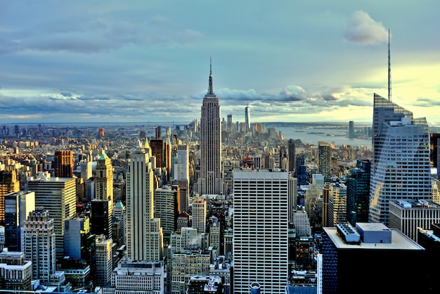 Sunset over manhattan with the empire state building in the center of the scene.