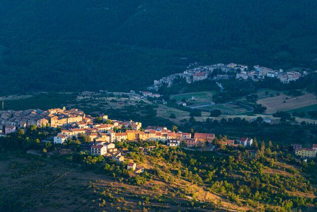 Sunset over medieval village perched on hill top, Abruzzo, Italy. Gran Sasso National Park, mountains landscape, tourism destination.