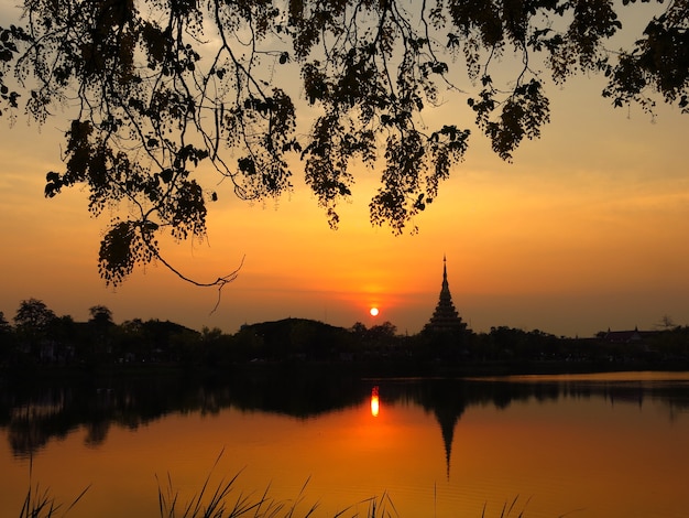 湖の寺院の近くの夕日