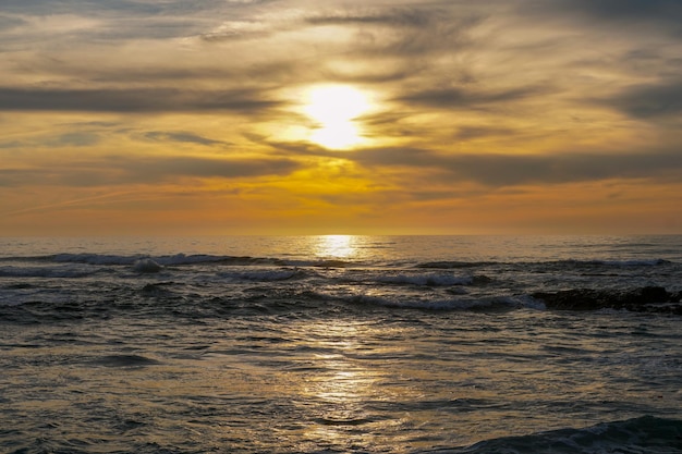 曇り空で海に沈む夕日