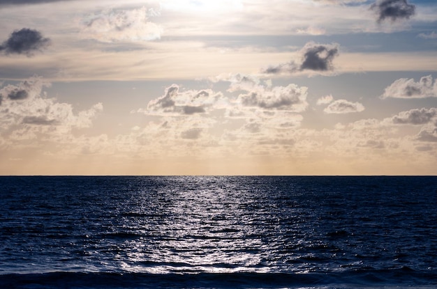 外海の夕日 自然の夕日または日の出の光と闇の海の波の背景を持つ水平写真