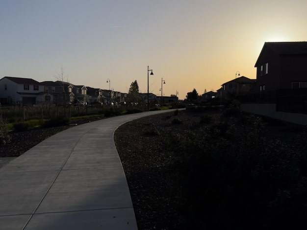 Sunset over a pathway flanked by houses