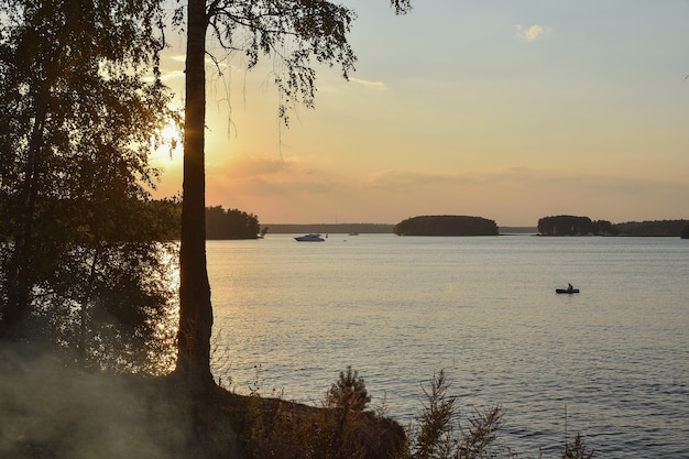 Sunset on the Pestovo reservoir, sunset on the lake, silhouette of birch