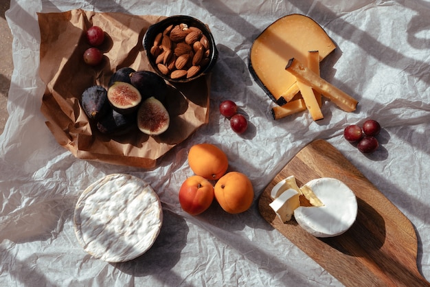 Foto picnic al tramonto con vari tipi di formaggio e frutta