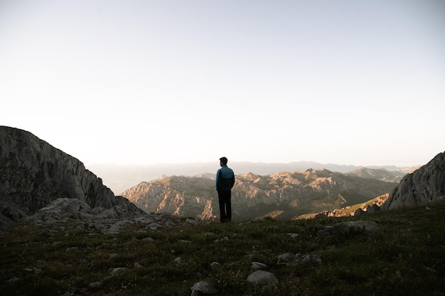 Photo sunset in picos de europa pico urriellu with hiker looking into the horizon