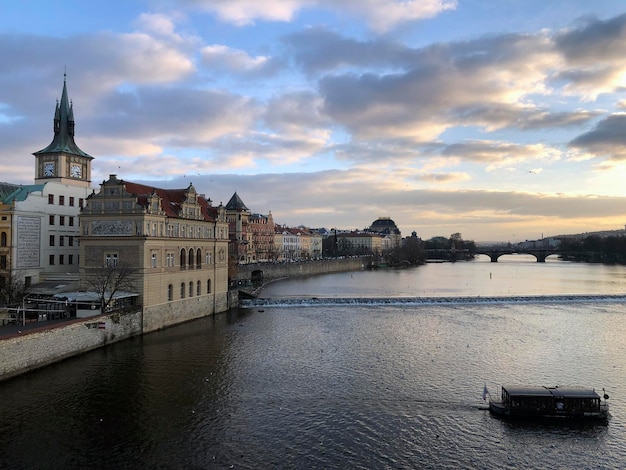 프라하의 일몰. 블타바 강(Vltava river), 화려한 하늘, 오래된 체코 건물이 있는 탁 트인 전망. 최고의 체코어